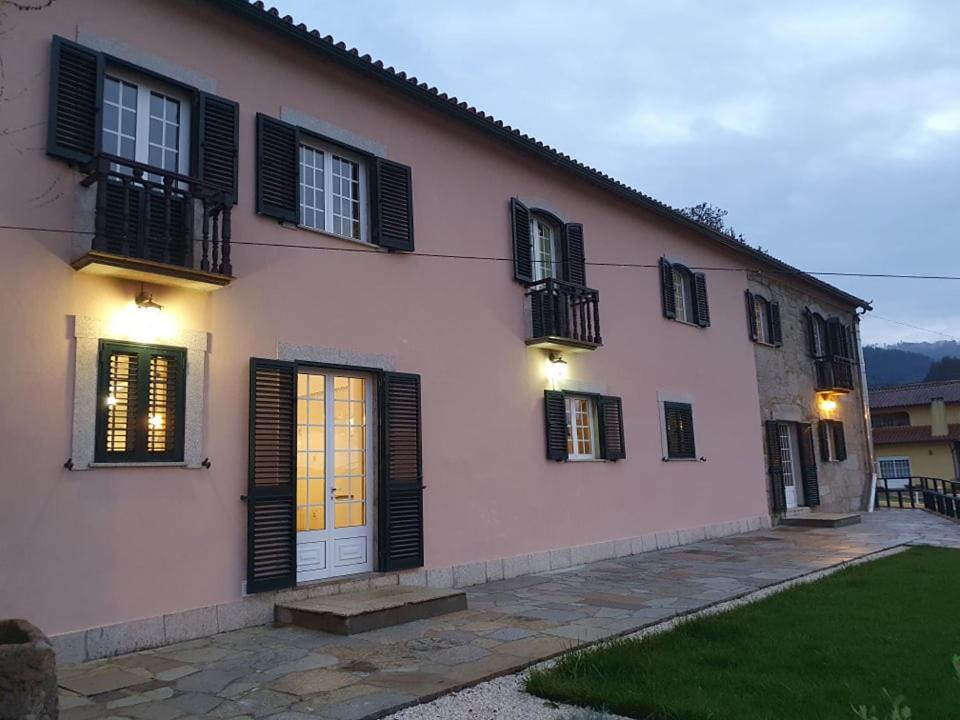 a house with black shutters and a yellow door at Quinta Viela Principal in Viseu