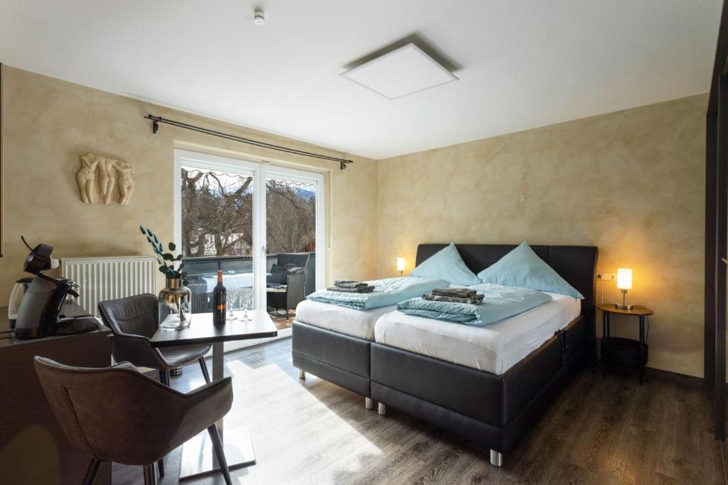 - une chambre avec un lit, une table et une fenêtre dans l'établissement Panoramahaus Hopfner Nähe Zugspitze und Eibsee, à Garmisch-Partenkirchen