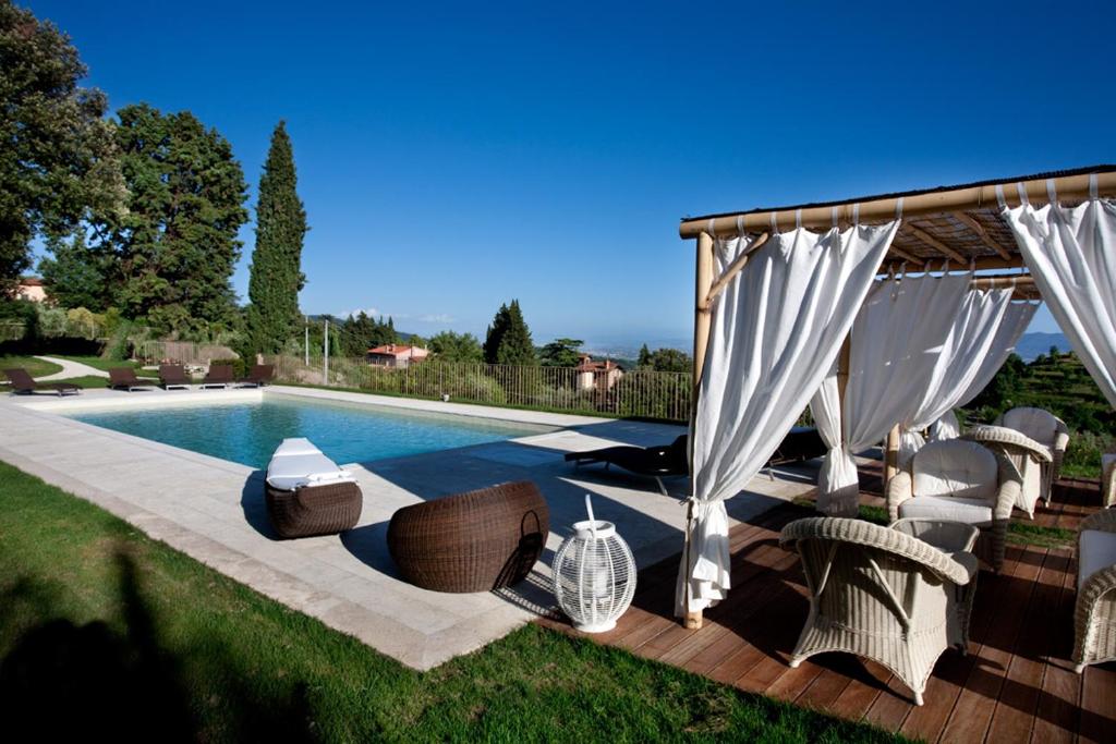 einem Pool mit Stühlen und einem Pavillon neben in der Unterkunft Villa Giorgia Albergo in Collina in Pistoia