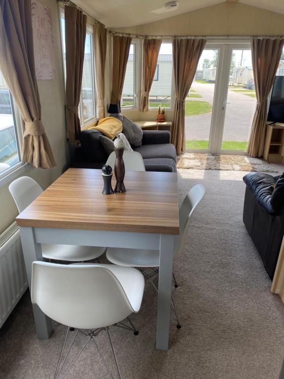 een eetkamer en een woonkamer met een tafel en stoelen bij 6 berth Seawick Caravan Park, St Osyth in Colchester