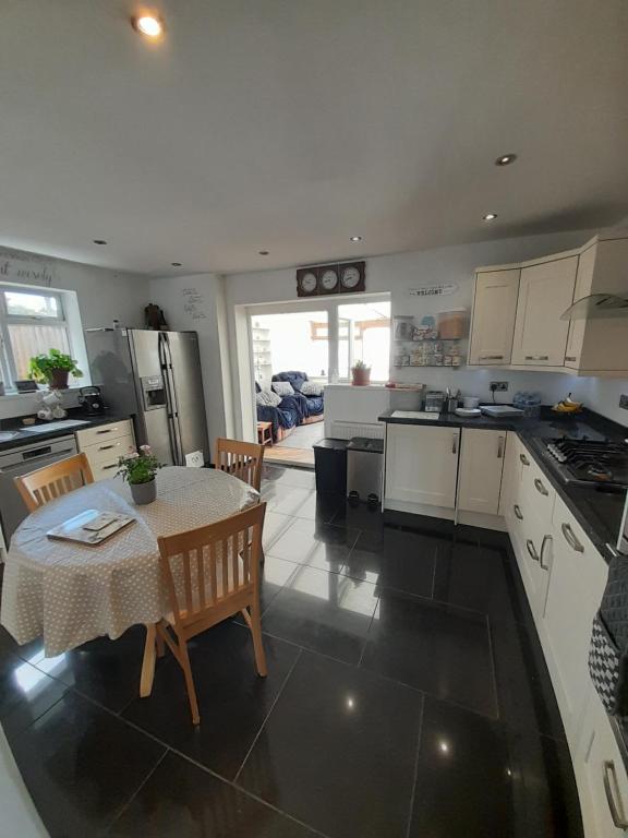 a kitchen with a table and a kitchen with a table and chairs at The Homestay Get Away in Kent