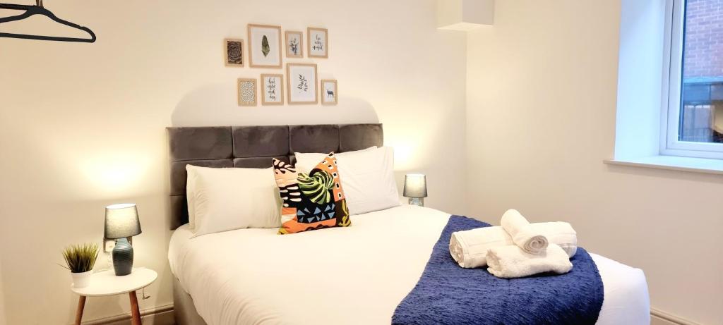 een slaapkamer met een groot wit bed en handdoeken bij Hounds Gate Luxury Apartments by 1508 Stays in Nottingham