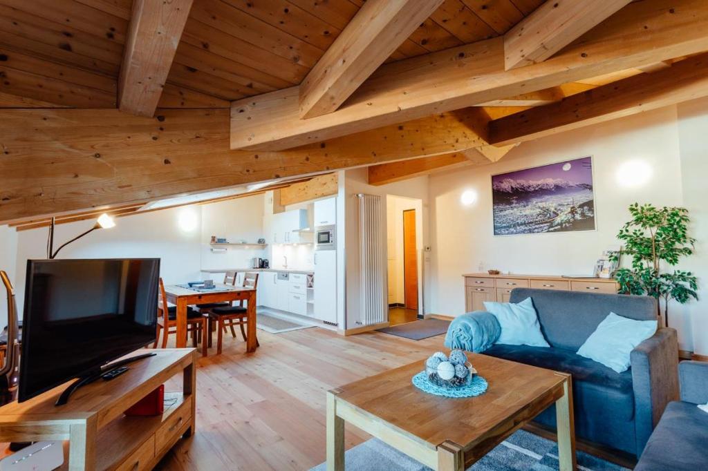 a living room with a blue couch and a table at Apartment Alexander by MoniCare in Seefeld in Tirol