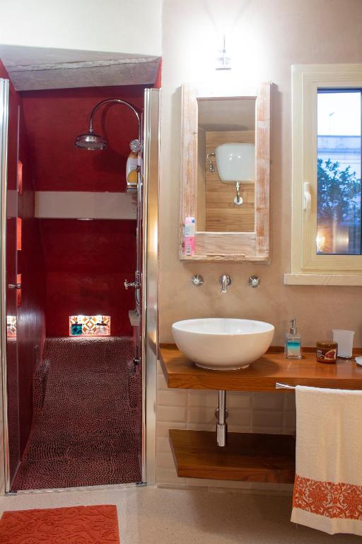 łazienka z białą umywalką i lustrem w obiekcie Amata Casa w mieście Muro Leccese