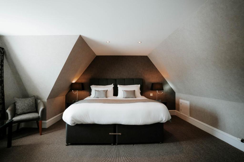 una camera da letto con un grande letto in mansarda di New Inn Hotel a Ellon
