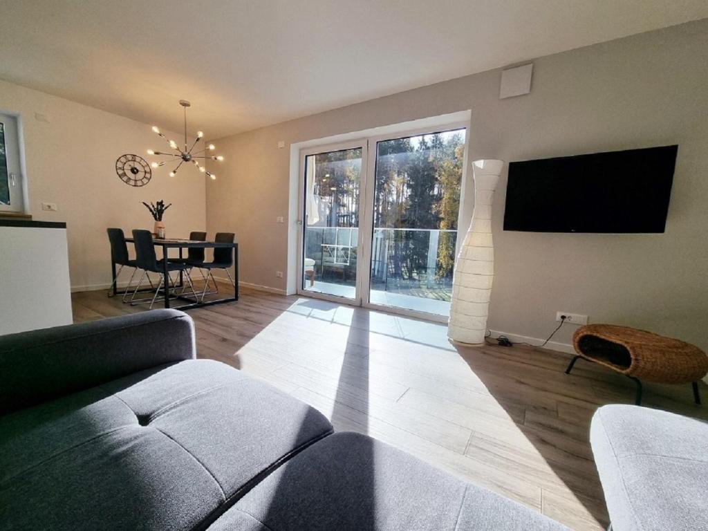 uma sala de estar com um sofá e uma televisão de ecrã plano em Maison Vert - Neuwertige Wohnung mit Terrasse em Collalbo