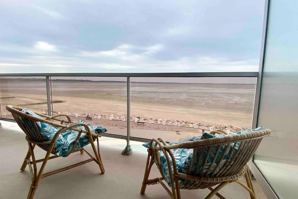 - deux chaises sur un balcon avec vue sur la plage dans l'établissement Studio avec balcon, vue panoramique sur la baie, au Crotoy