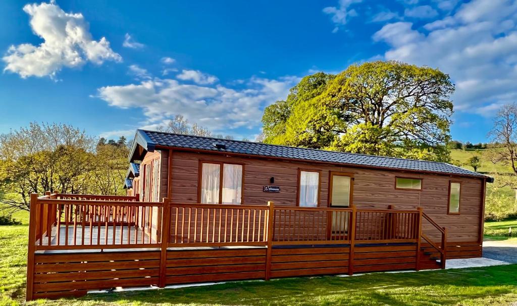 a wooden cabin with a large deck at Lillypool Lodges in Cheddar