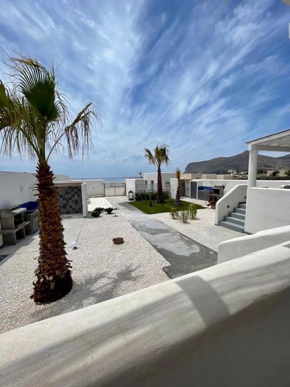 a palm tree sitting on the side of a building at Le Casuzze Ammare in Favignana