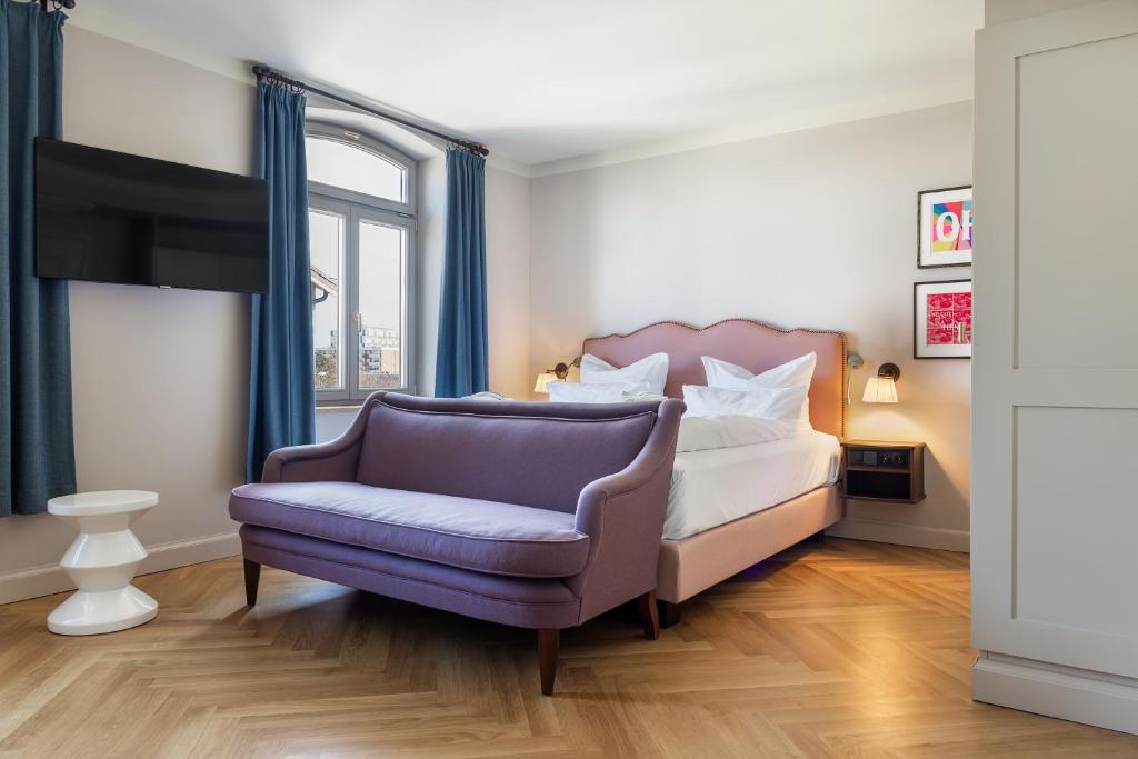 1 dormitorio con 1 cama y 1 silla en Mimosa Suites en Westerland