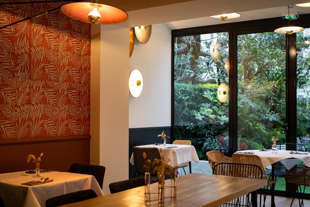 a restaurant with two tables and a large window at Hotel Molière in Cannes