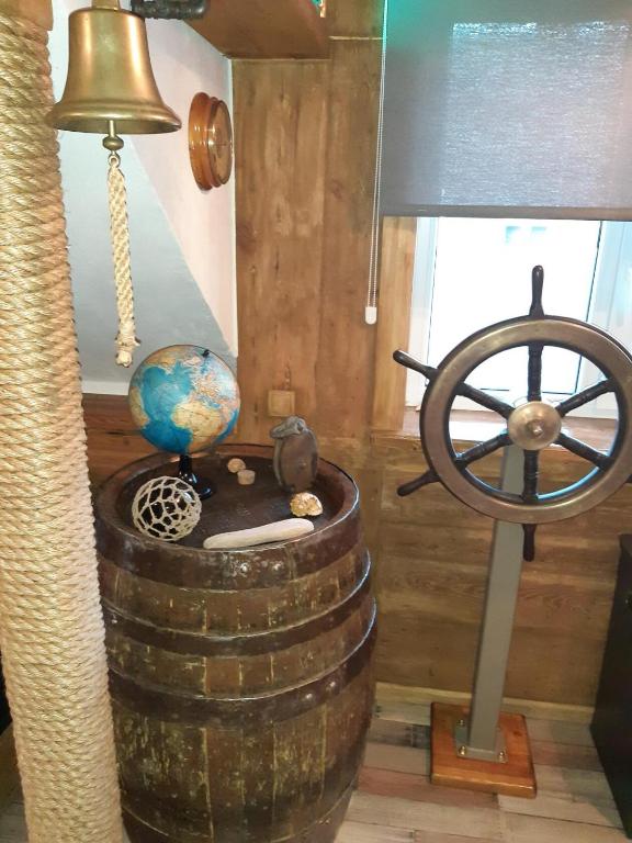 a room with a steering wheel and a barrel with a globe at Yacht Club in Liepāja