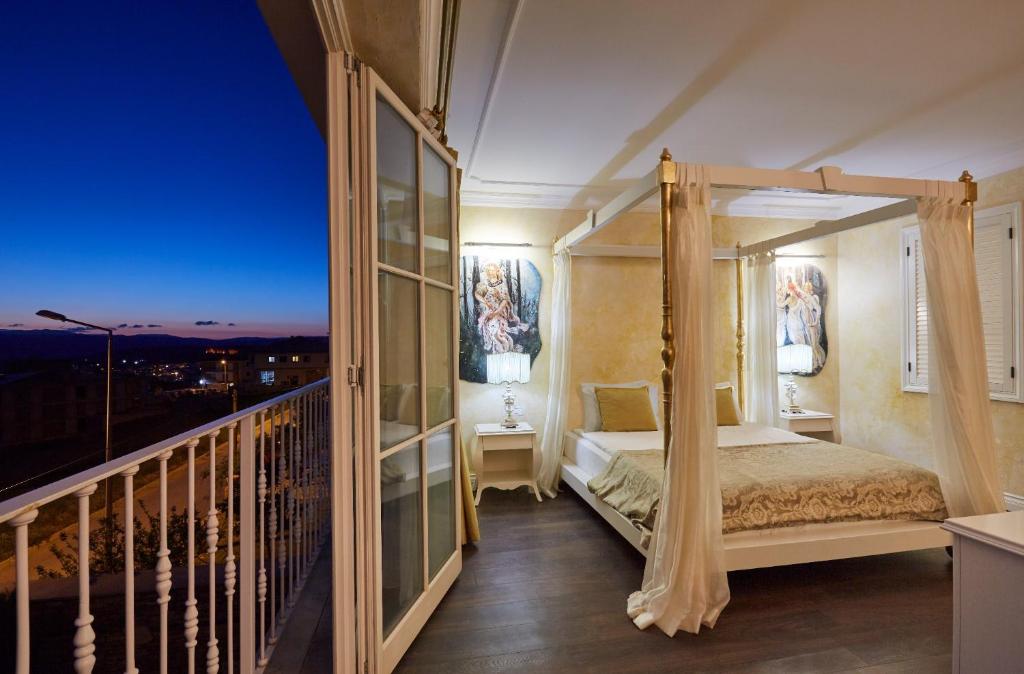 a bedroom with a canopy bed on a balcony at Vinifera Ephesus Hotel in Selcuk