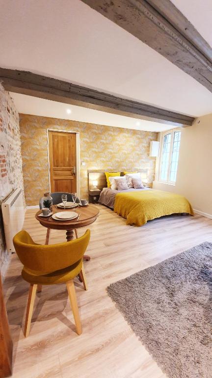 une chambre avec un lit, une table et un canapé dans l'établissement Nid du puits : charmant studio centre Honfleur, à Honfleur