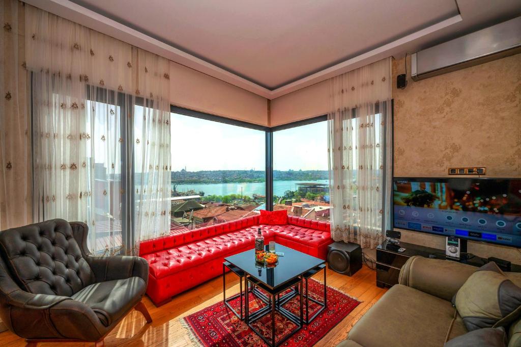 sala de estar con sofá rojo y ventana grande en O'Pera Okanlı Suites en Estambul