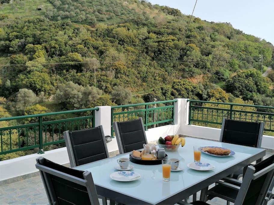 a table with food and fruit on top of a balcony at Villa Araxovoli in Palaiochóra