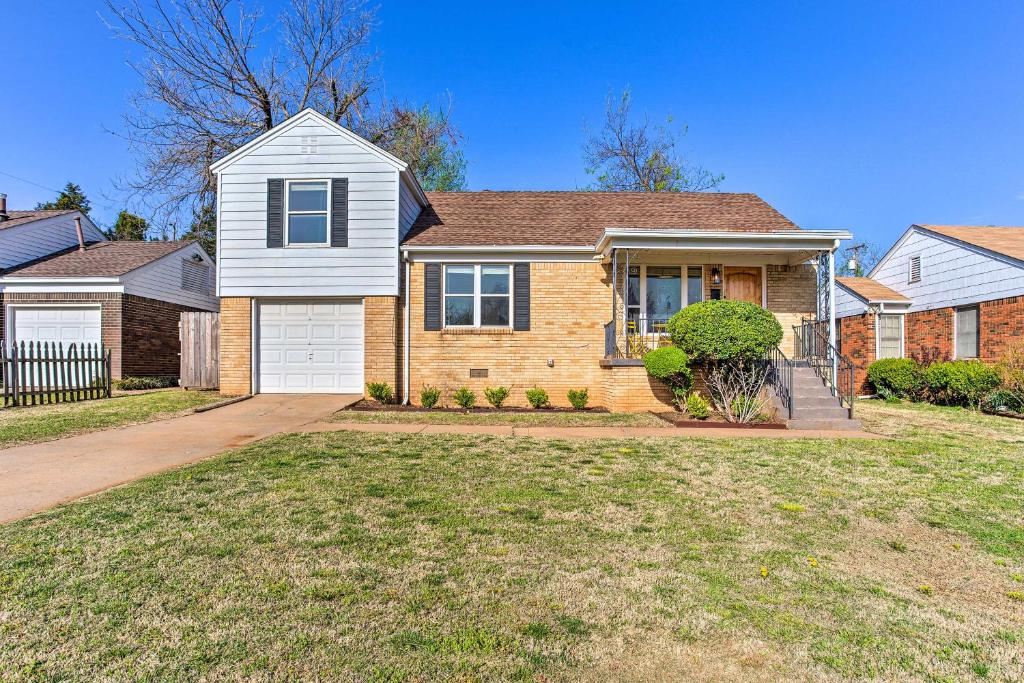 a brick house with a driveway in a yard at Family-Friendly OKC Home with Large Yard and Deck in Oklahoma City