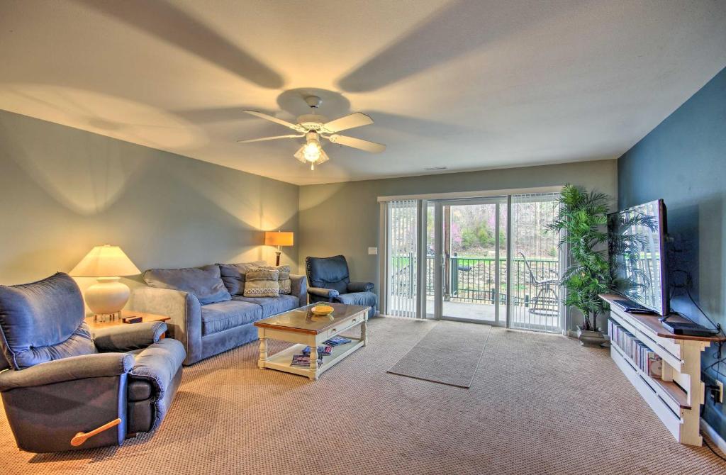 a living room with a couch and a tv at Spacious Lakefront Condo with Community Pools! in Camdenton