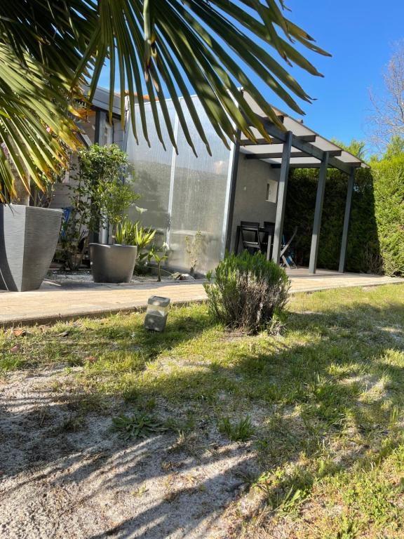 uma casa com um pátio com sombra e um edifício em Lo em Audenge