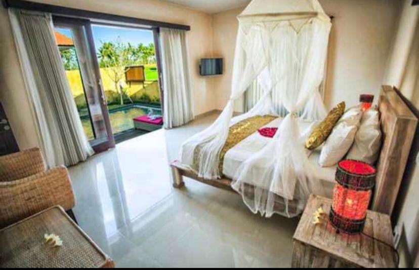 a bedroom with a bed with a canopy at The Sawah Resort & Villa in Ubud