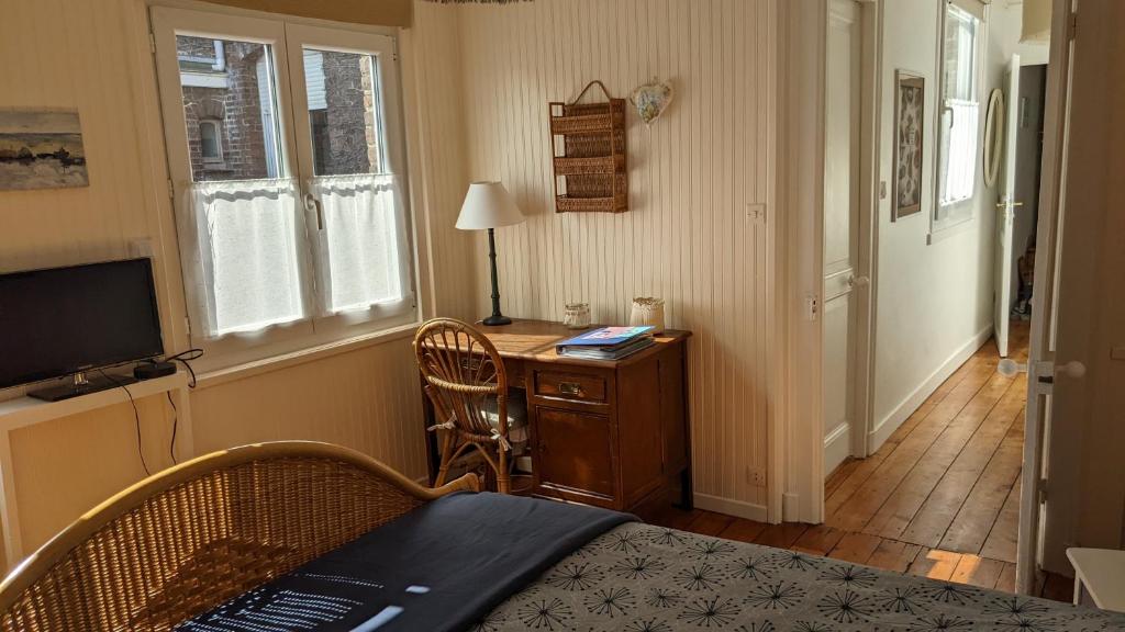 een slaapkamer met een bureau, een bed en een televisie bij Rêve Bleu in Duinkerke