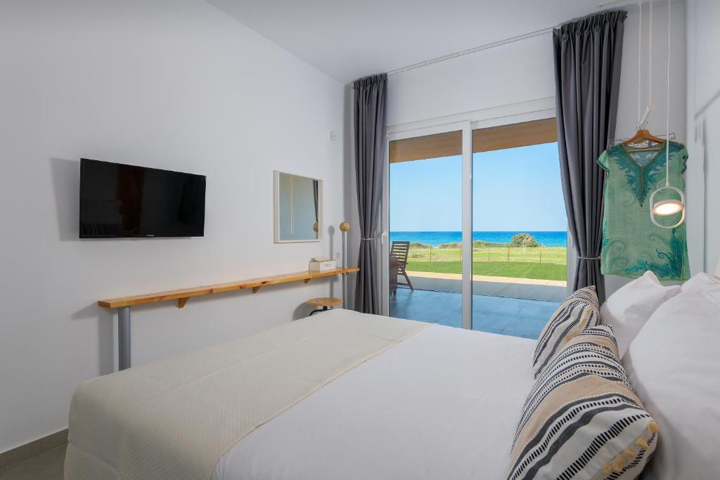 1 dormitorio con cama y vistas al océano en Niva Kamiros Apartments en Kamiros