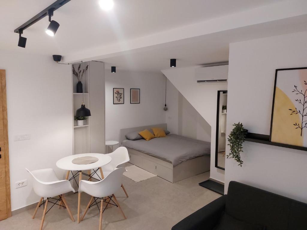 a small room with a bed and a table and chairs at Casa Gray in Koper