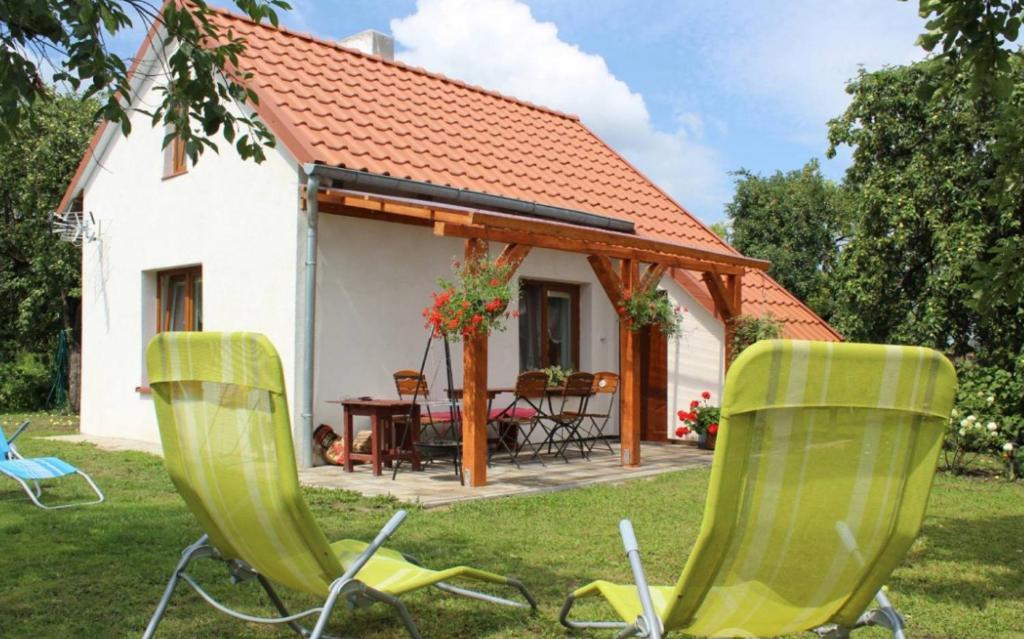 zwei Stühle im Gras vor einem Haus in der Unterkunft Domek w sadzie in Sterławki Wielkie