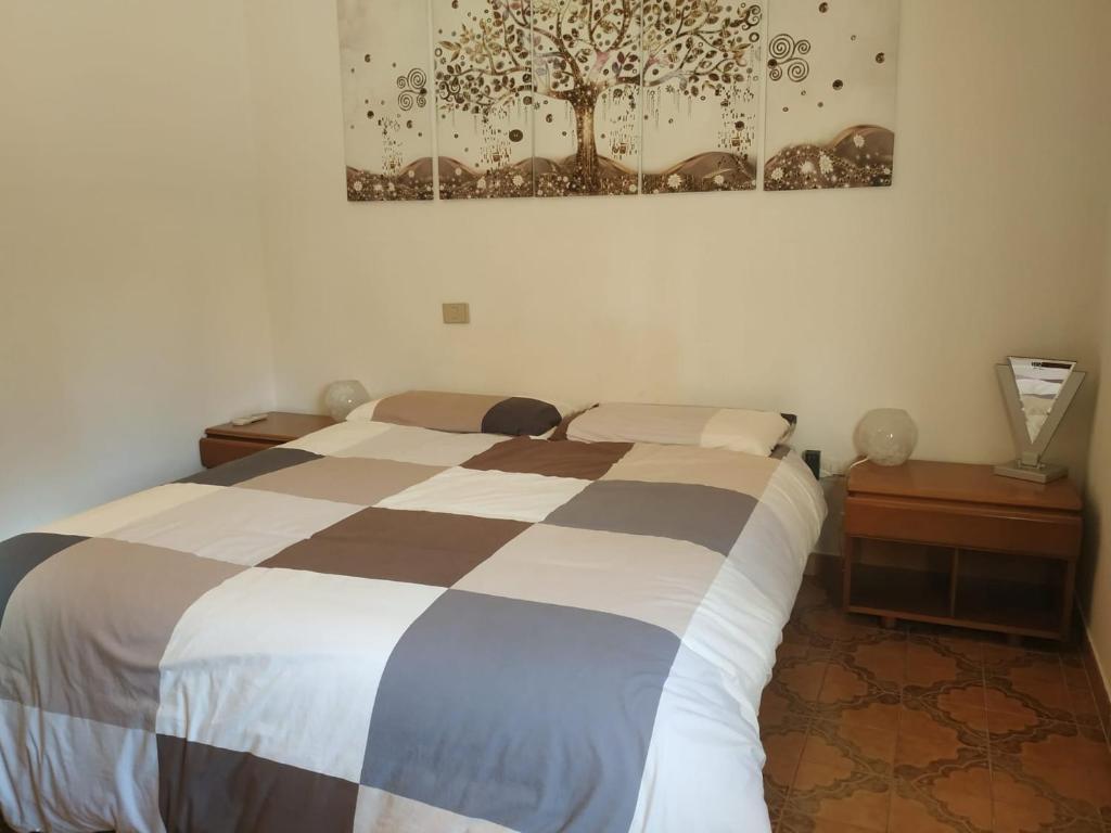 ein Schlafzimmer mit einem Bett, zwei Tischen und einem Gemälde in der Unterkunft Casa Poggio in Cagliari