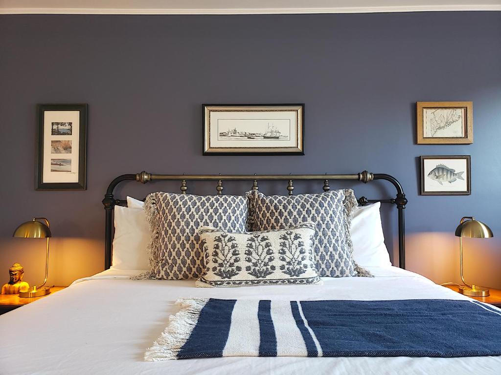 1 dormitorio con paredes azules y 1 cama con almohadas en Little Fig Hotel en Bar Harbor