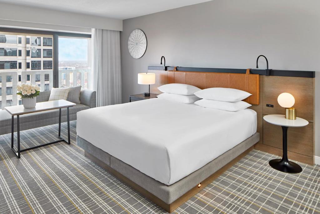 um quarto com uma grande cama branca e um sofá em Hyatt Regency Atlanta em Atlanta