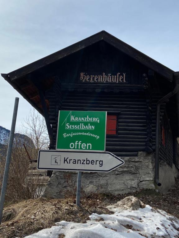 una señal frente a un edificio de madera en Hexenhäusl en Mittenwald