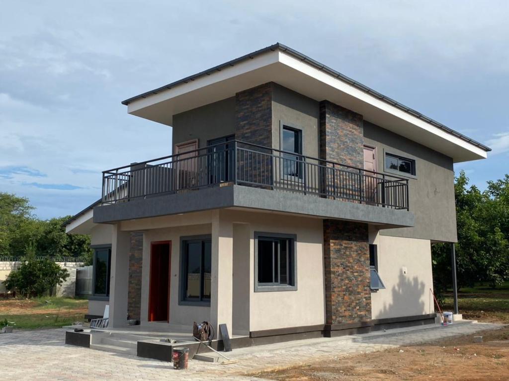 a house with a balcony on top of it at Exclusive Farm Getaway in Lusaka