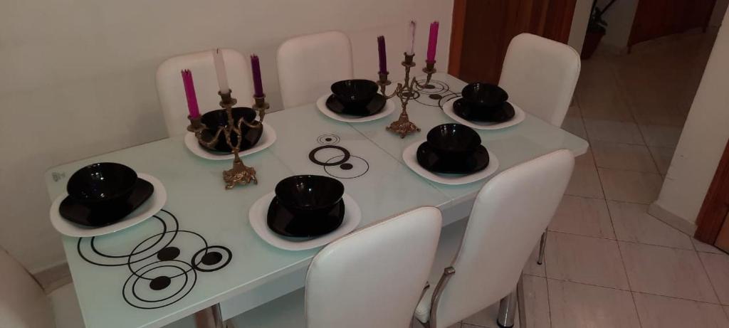 einen weißen Tisch mit Hüten und Kerzen darauf in der Unterkunft Raha in Fès