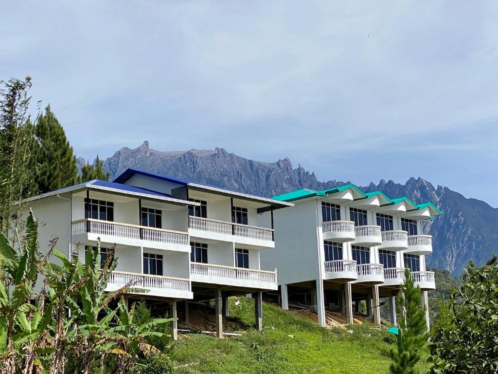 um edifício numa colina com montanhas ao fundo em JR RESORT em Ranau