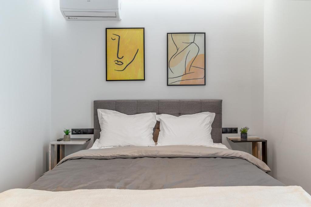 a bedroom with a bed with three pictures on the wall at Athena Studio in Gazi in Athens