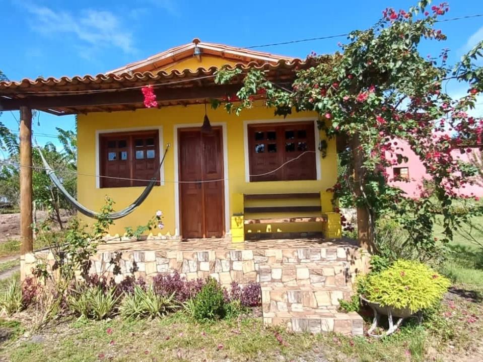 una casa amarilla con techo rojo en Pousada Serra Aquarela - Mini casas en Ibicoara