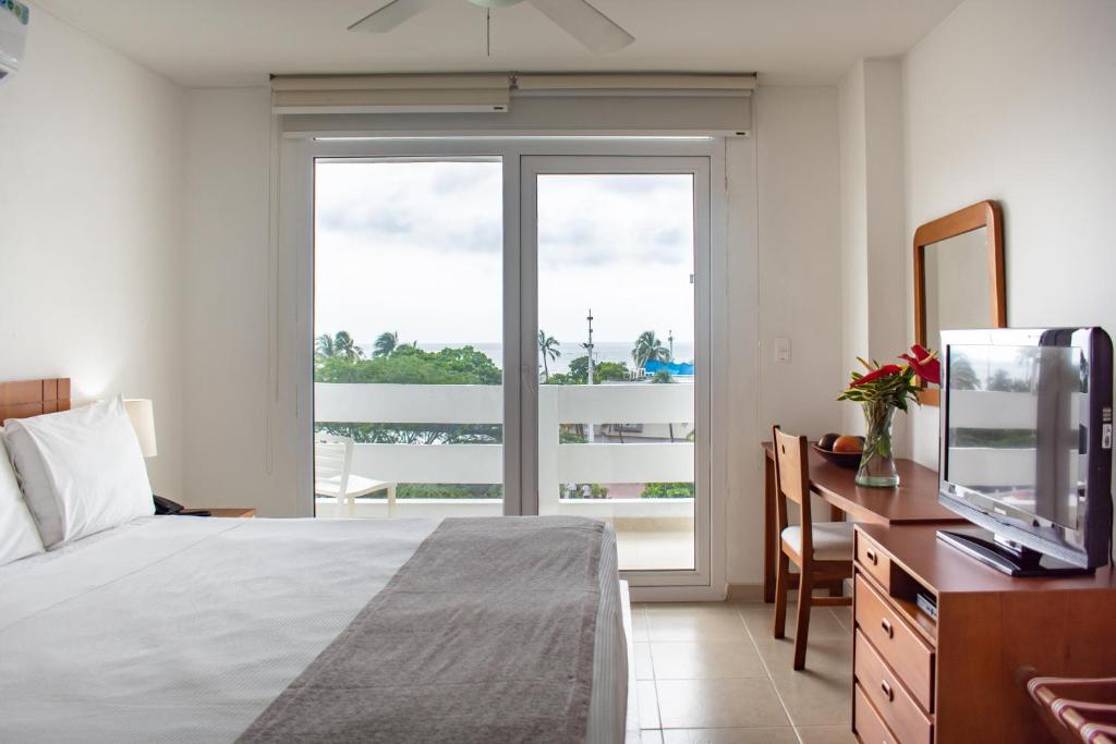 ein Schlafzimmer mit einem Bett und einem großen Fenster in der Unterkunft Blu Hotel by Tamaca in Santa Marta