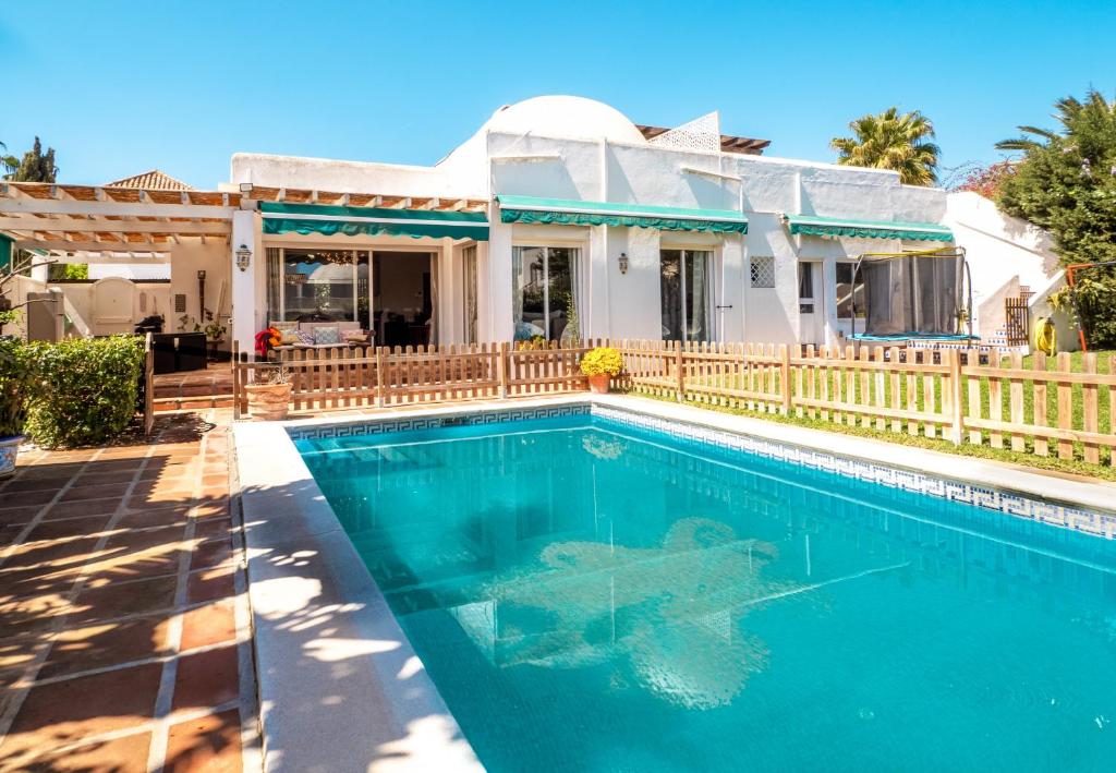 a swimming pool in front of a house at Villa Happy River in Marbella
