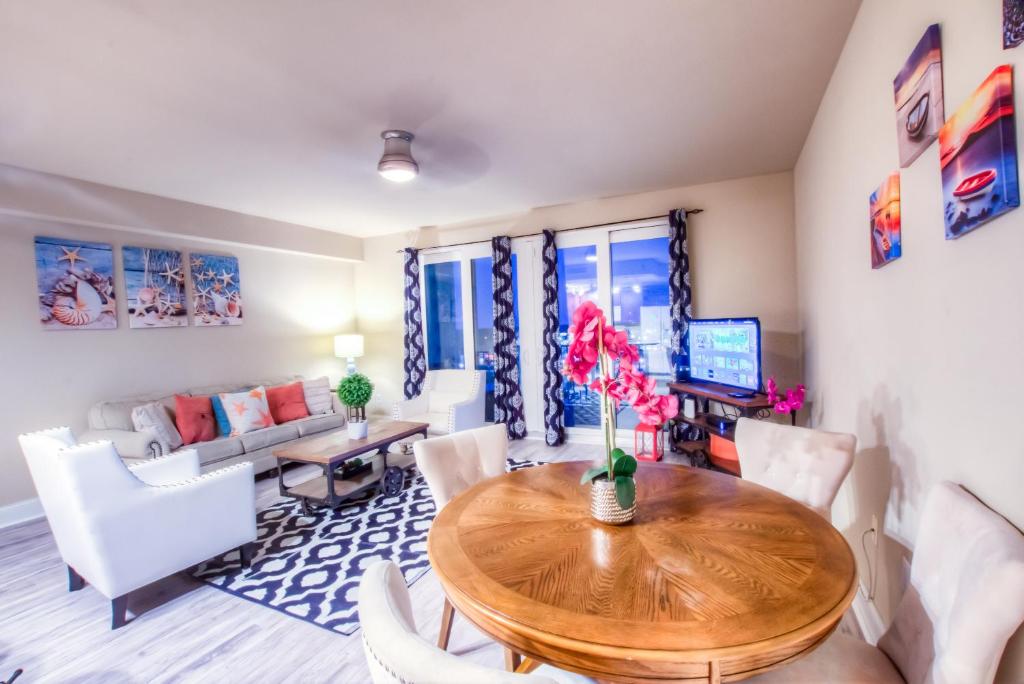 a living room with a wooden table and chairs at Laketown Wharf Resort 1036 By Aneliya in Panama City Beach