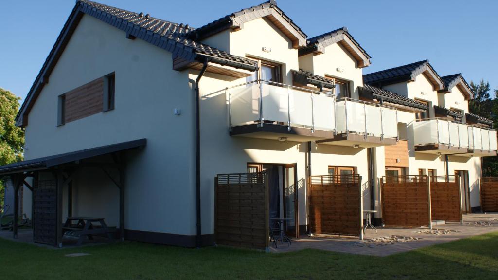 ビチェにあるApartamenty Domki Pokoje WeMa Wicieのバルコニー付きの大きな白い家