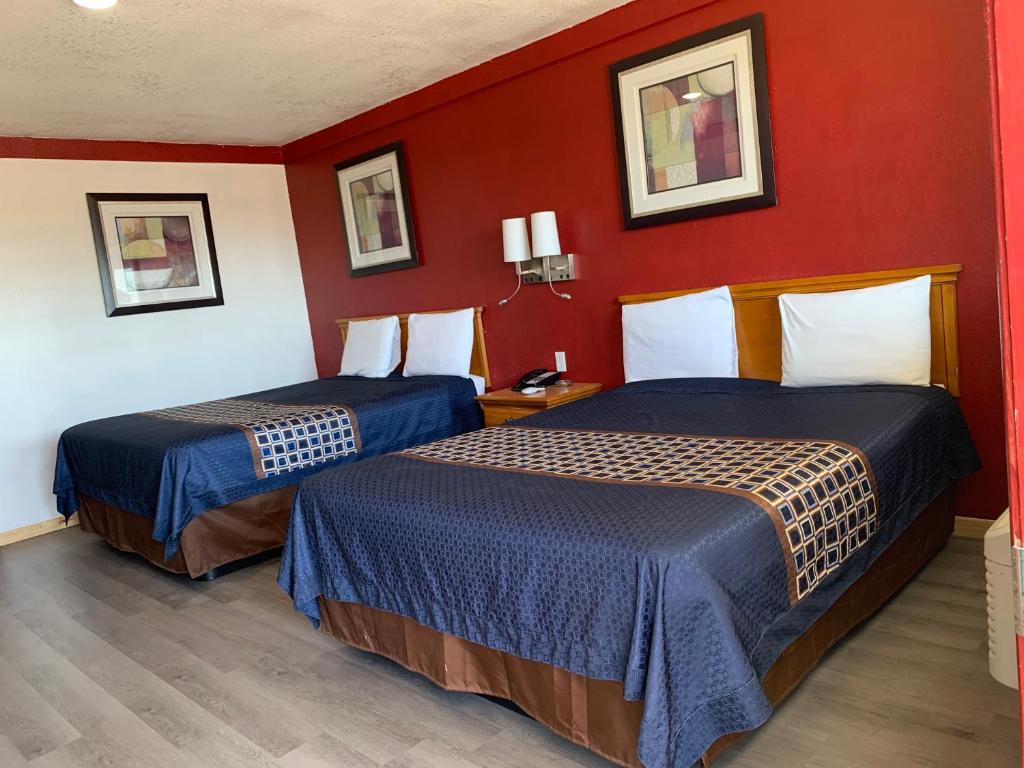 two beds in a hotel room with red walls at Budget Inn in Memphis