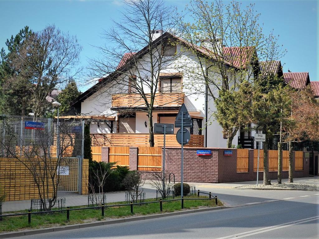 una casa al lado de una calle con una valla en Dom Stegny en Varsovia