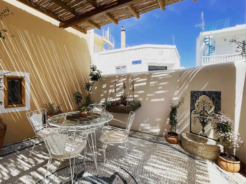 Un patio con una mesa y sillas en un balcón. en Rose traditional house, en Archangelos