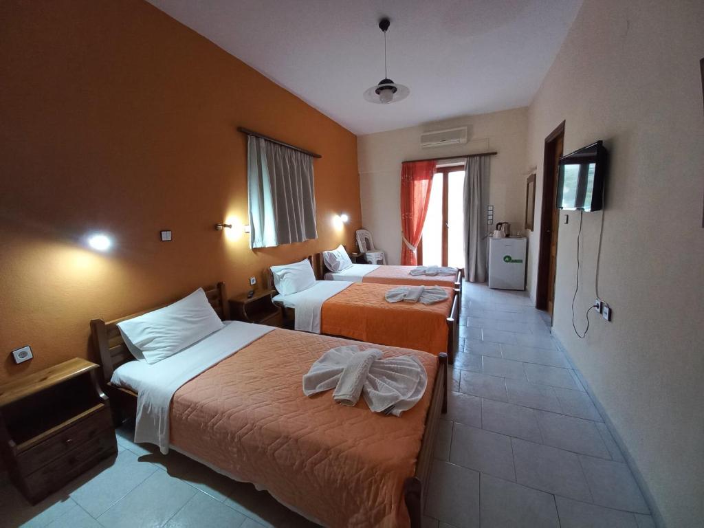 pokój hotelowy z dwoma łóżkami i telewizorem w obiekcie Castro Kerame w mieście Kerames