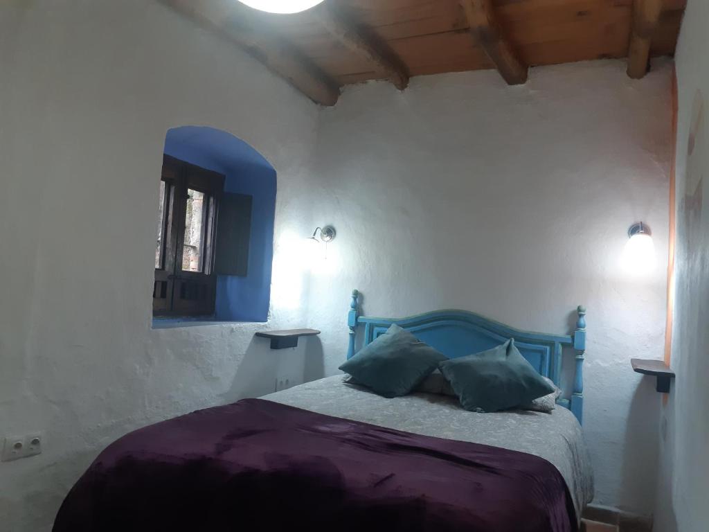 A bed or beds in a room at Bonita Casa Rural en la Sierra de Aracena
