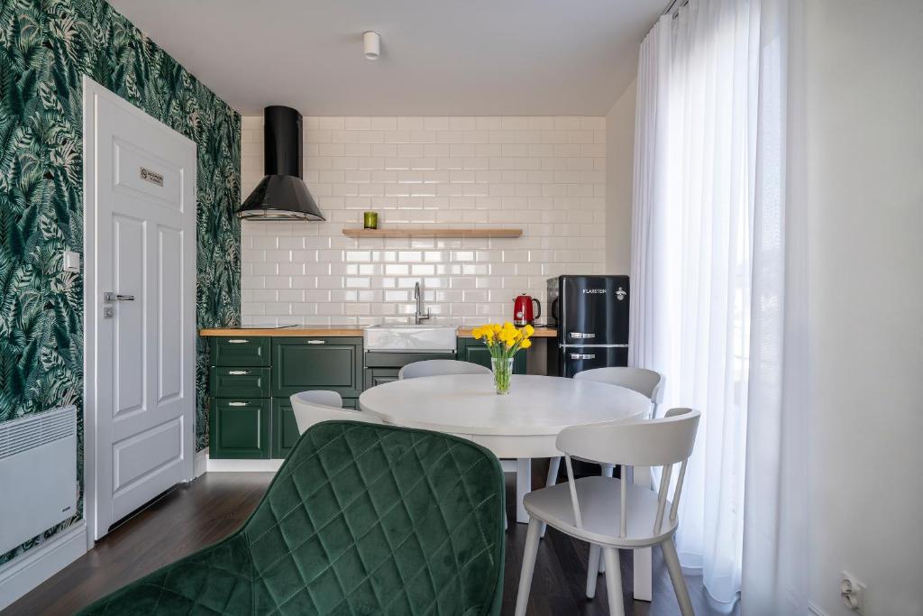 cocina con mesa blanca y armarios verdes en W Starym Porcie en Krynica Morska