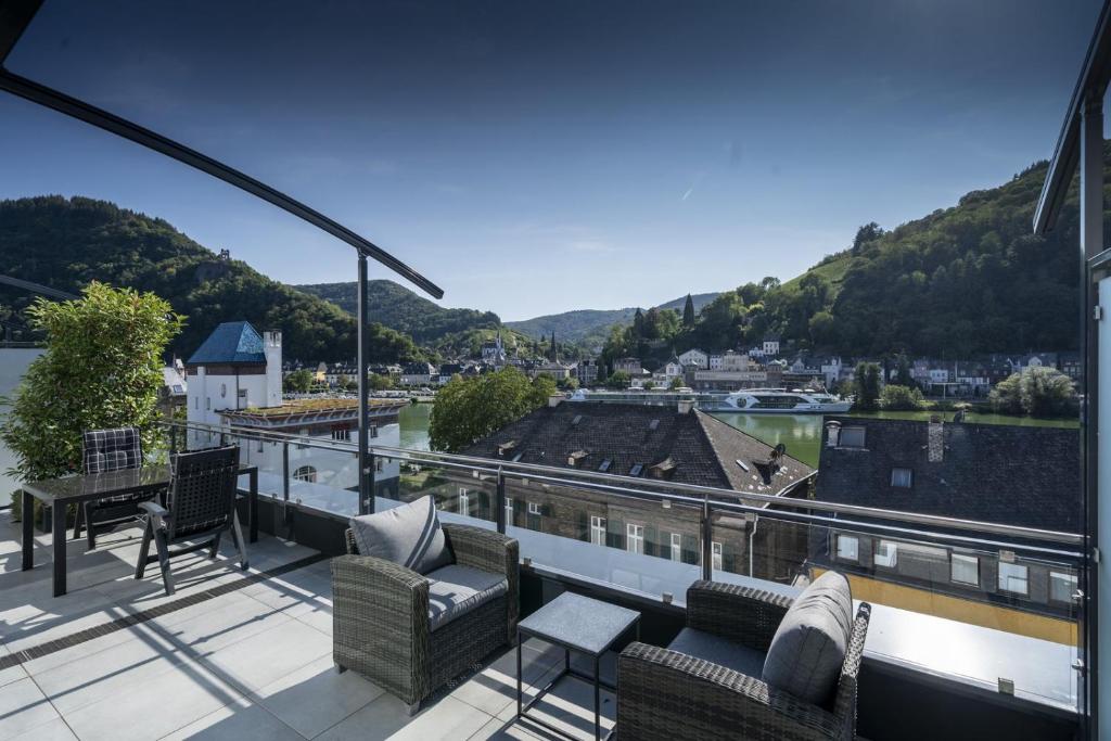 a balcony with chairs and a view of a river at NEU MoselTOP Penthouse - traumhaft in Traben-Trarbach