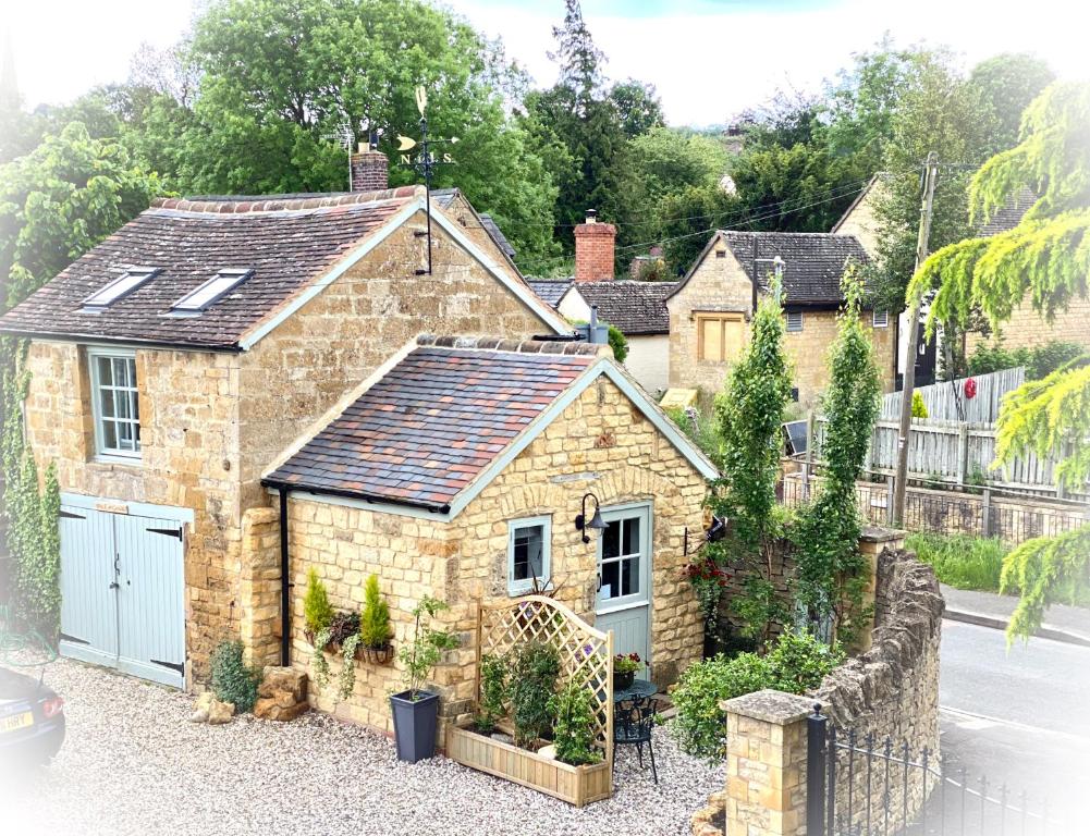 an old stone house with a blue garage at The Loft in the Malt Barn Chipping Campden in Mickleton