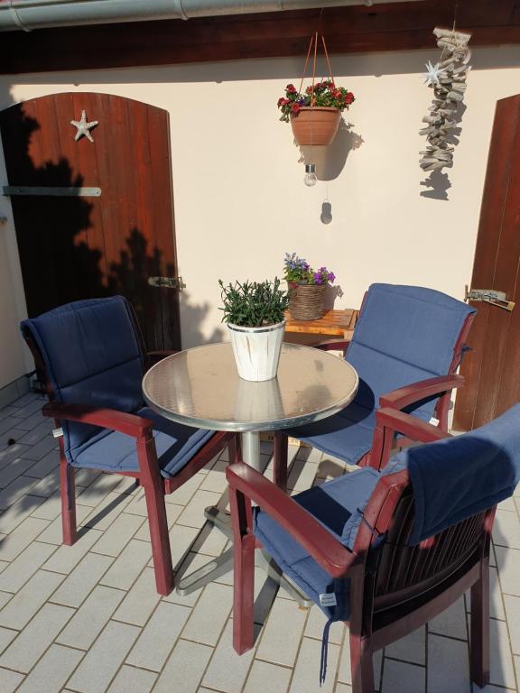 una mesa y sillas con una maceta en un patio en Ferienwohnung Gohlke en Stralsund